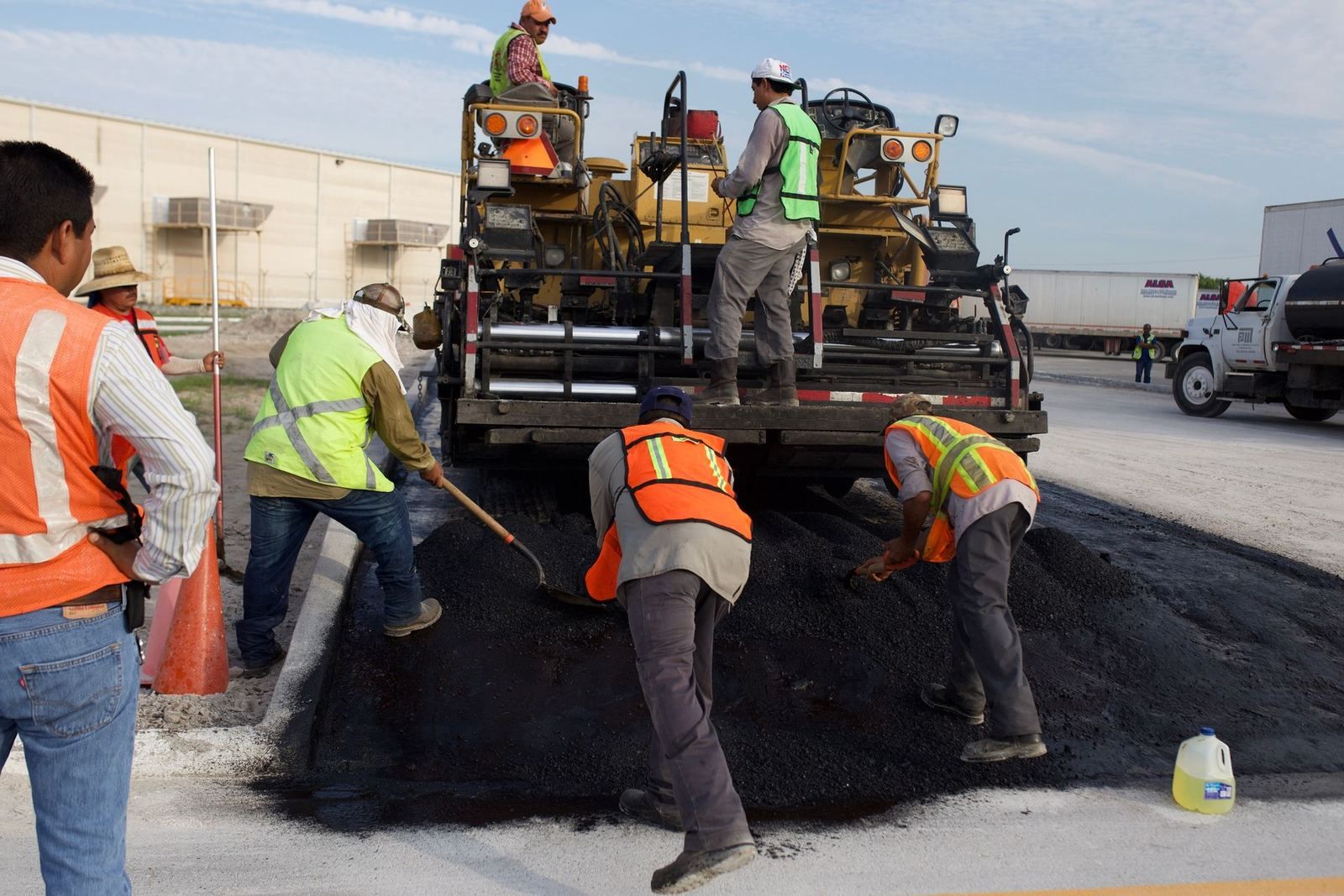 Road crew placing asphalt with a paving machine (stock photo)
